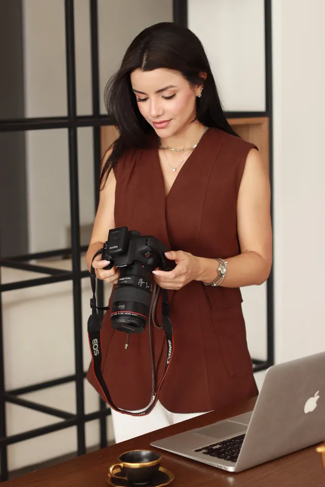 Dra. Vanessa Cristina segurando uma câmera fotográfica